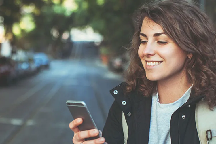 Mujer sonriendo mientras usa Apple Pay