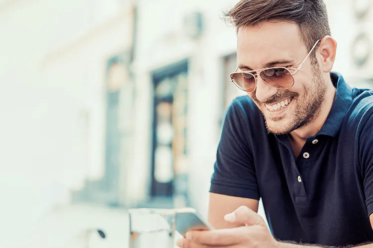 Hombre sonriendo mientras usa Samsung Pay